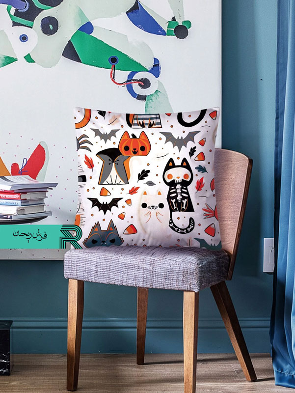 کوسن مخمل طرح دیجیتالی گربه و خفاش زمینه سفید با تم نارنجی روی صندلی