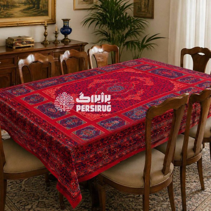 رومیزی سفره روفرشی آذین سرخ با زمینه قرمز و طرح سنتی ایرانی، دارای نقوش ظریف و چشمنواز در رنگهای قرمز و سرمهای.