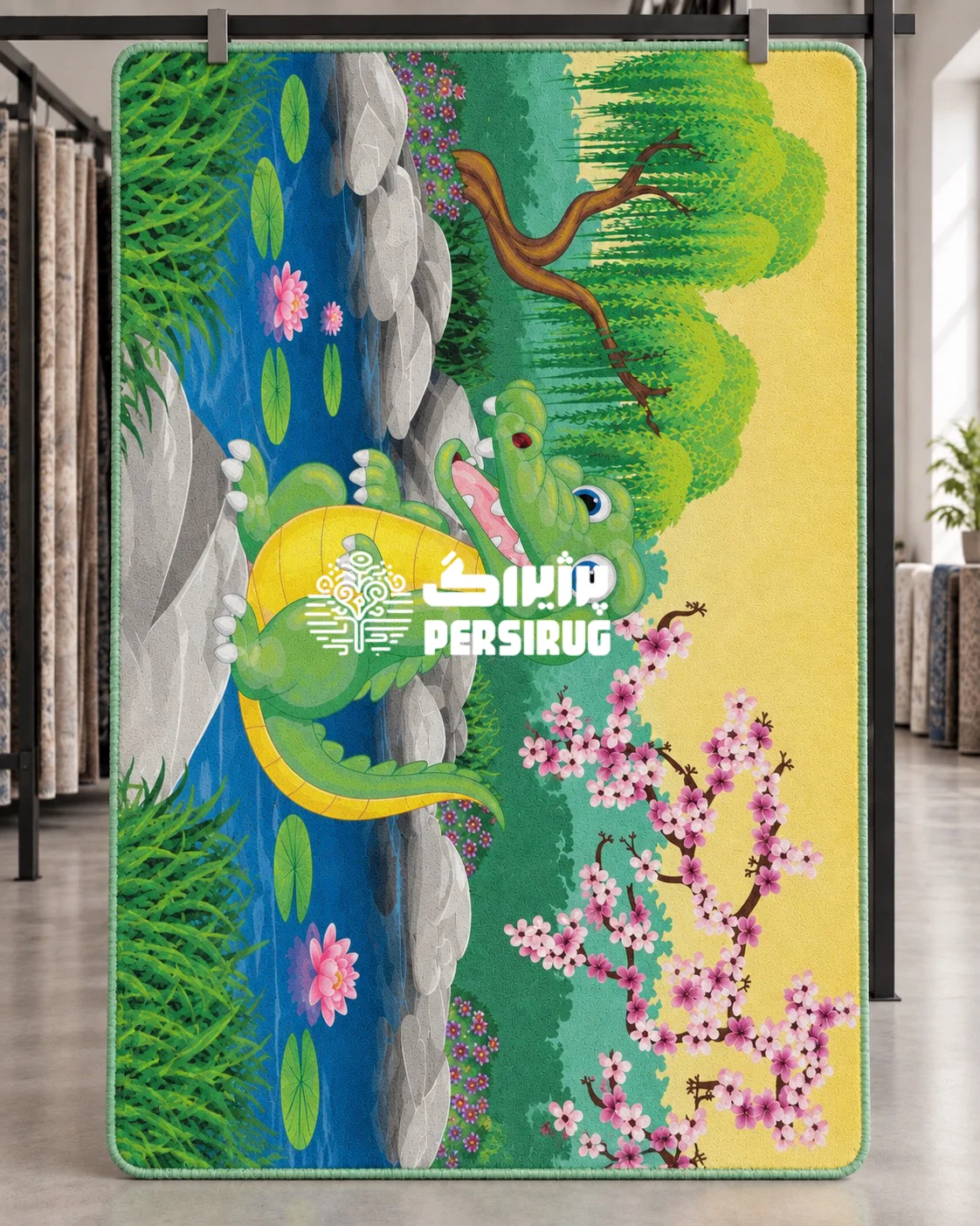 پادری زیره چرم کودک با تصویر تمساح کارتونی خندان کنار آب، میان سنگها و برگهای نیلوفر آبی، درختان سبز و شکوفههای صورتی.